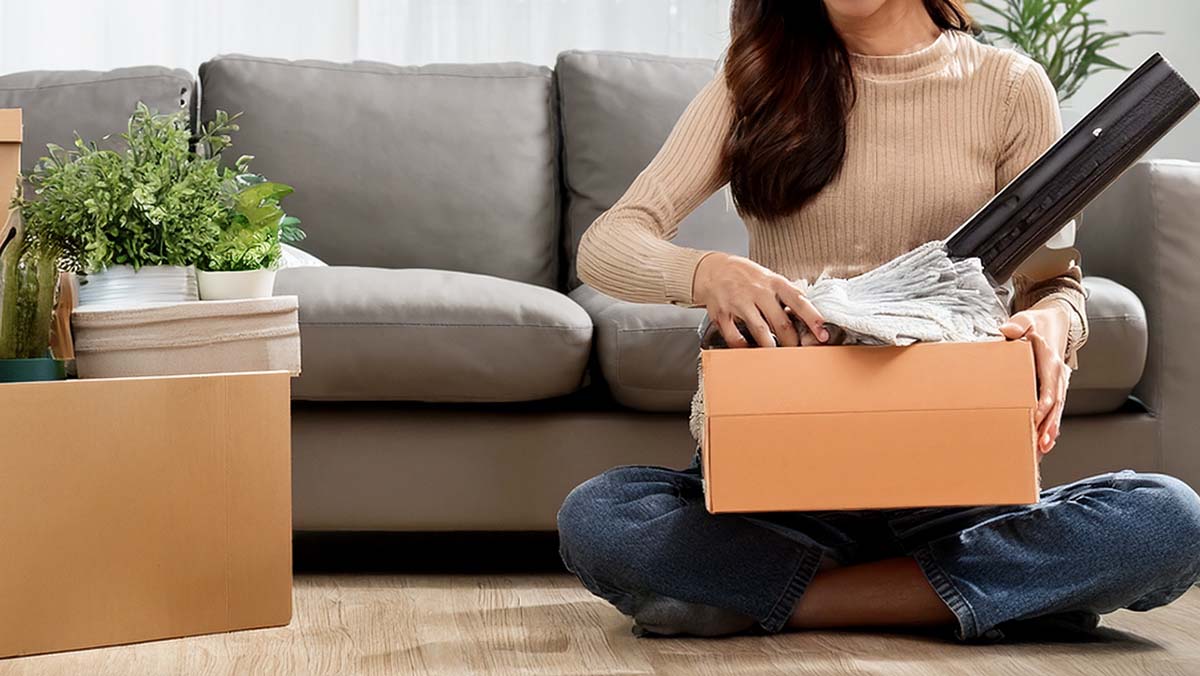 Woman Packing Box On Floor