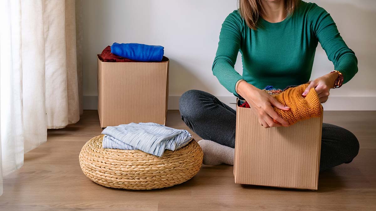 Woman Sorting Out Clothes In Boxes