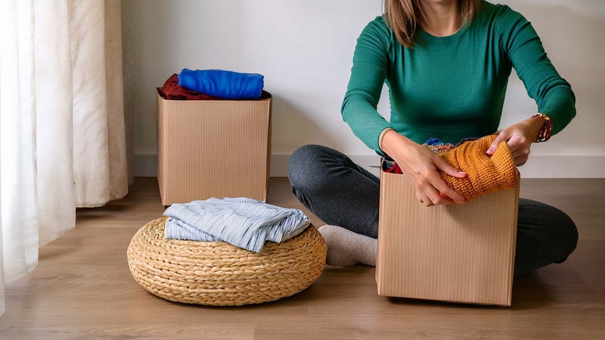 Woman Sorting Out Clothes In Boxes
