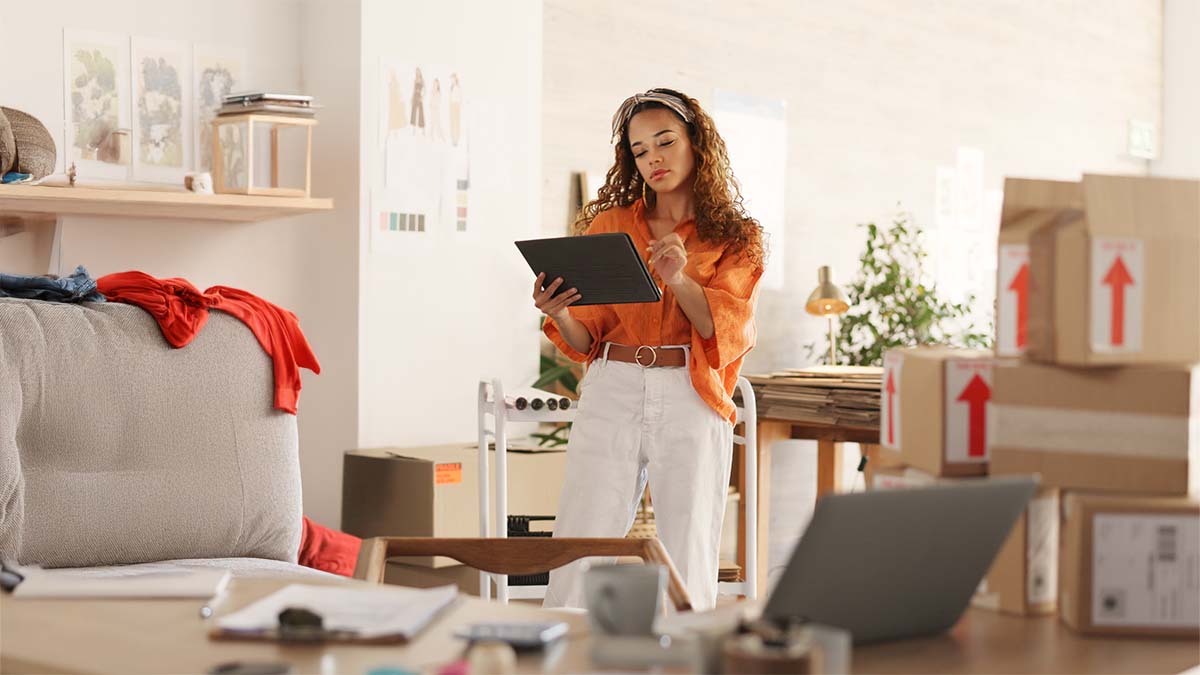 Woman With Tablet In Cluttered Room